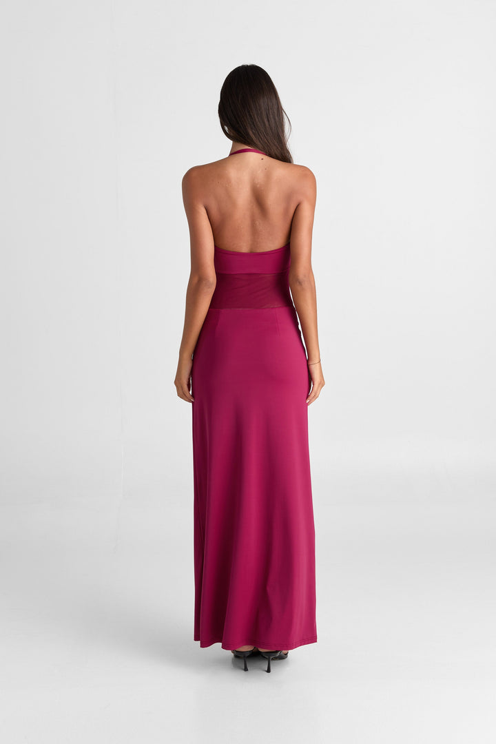 Woman wearing a long magenta dress on a white background
