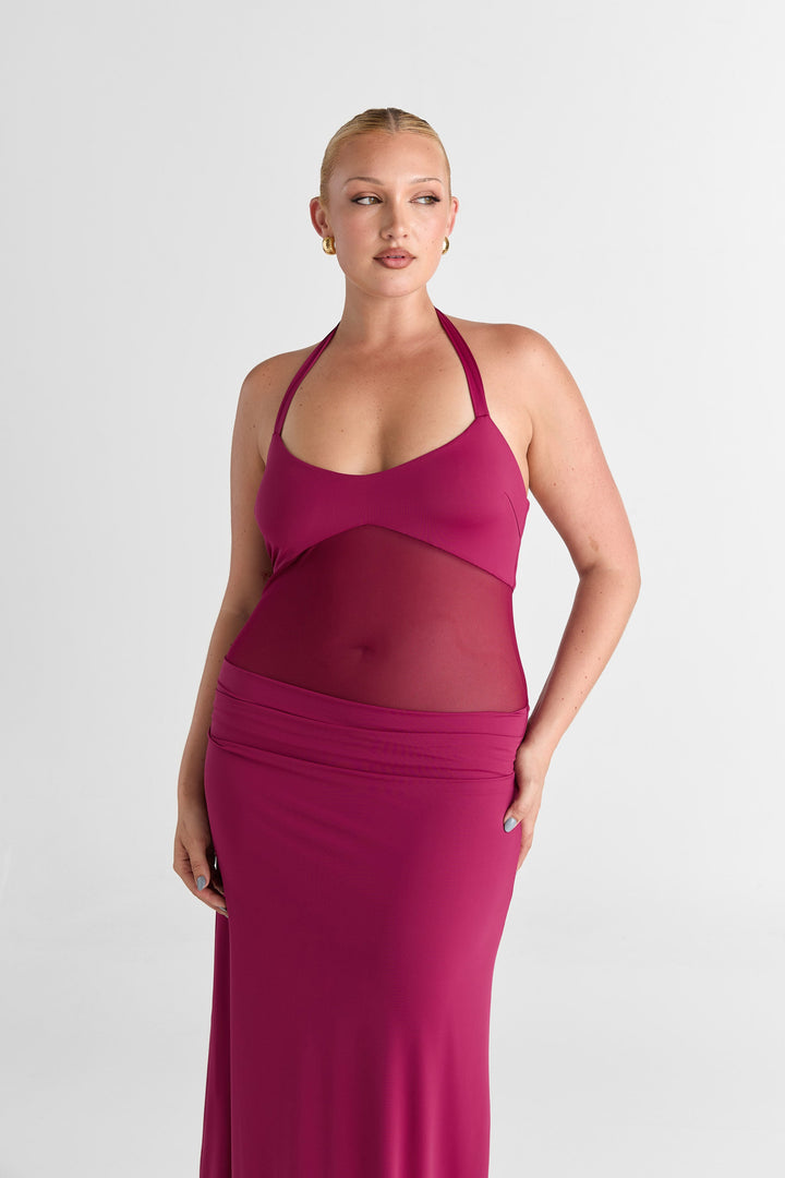 Woman wearing a pink dress with mesh panels on a white background