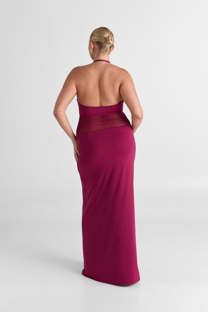 Woman wearing a magenta evening gown on a white background