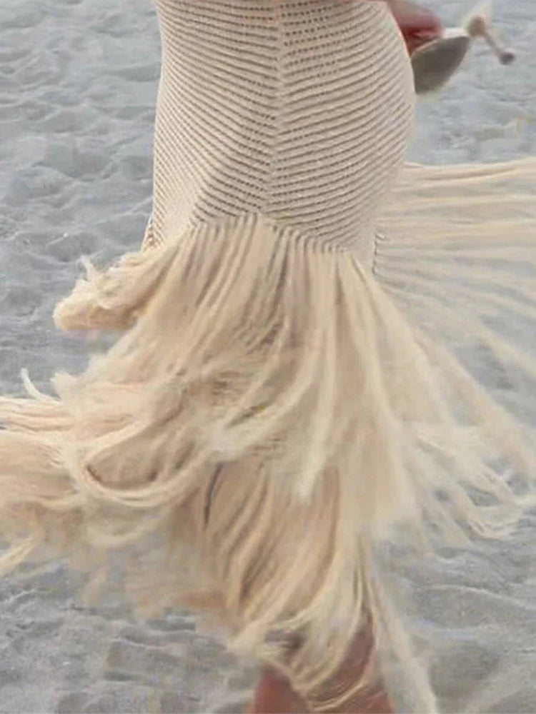 Beige mermaid-style dress with fringe details on a textured surface
